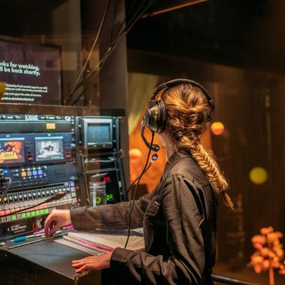 Deputy Stage Manager working at a cueing desk overlooking the stage
